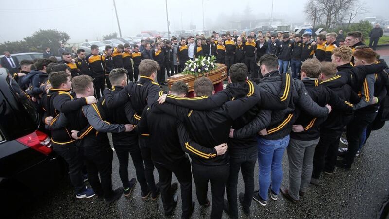Teammates and members of Pomeroy Plunketts GAC form a circle around the coffin of Christopher Colhoun in moving scenes at his funeral in Clonoe, Co Tyrone. Picture by Mal McCann 