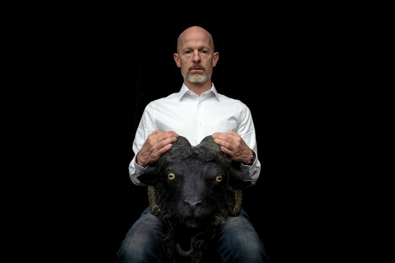 A photograph of Michael Keegan Dolan with a ram's skull