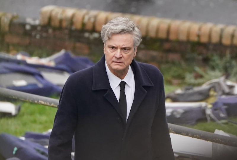 Colin Firth looks troubled as he walks through a scene recreating Lockerbie, following the events of the bombing
