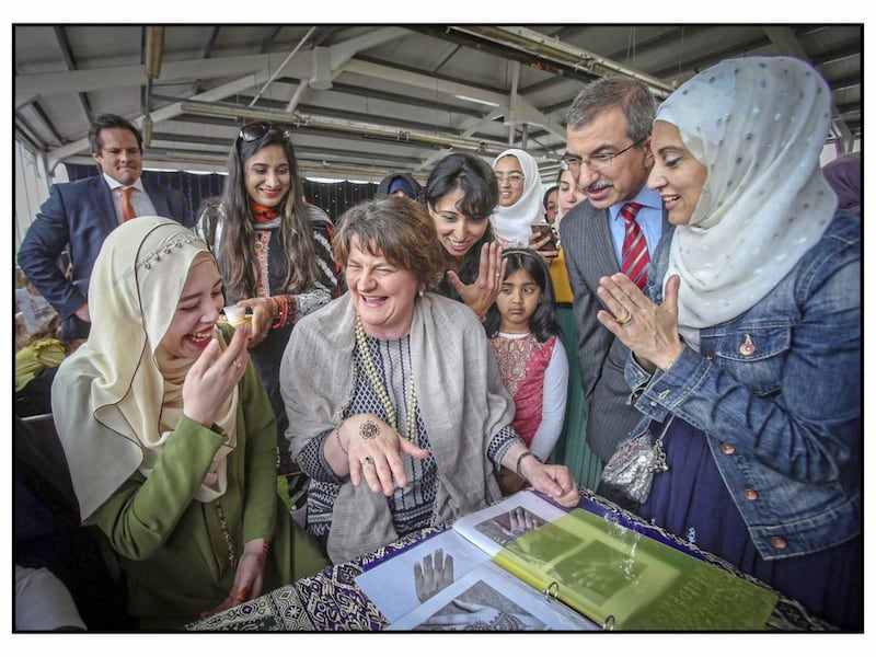 DUP leader Arlene Foster gets a henna tattoo from Syifaa Nabir at an event marking the end of the Muslim holy month of Ramadan. Picture by Mal McCann. 