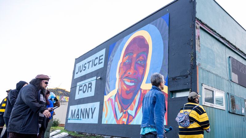 A crowd that included family members of Mr Ellis gathered near a mural of him in Tacoma on Thursday night (AP Photo/Maddy Grassy)