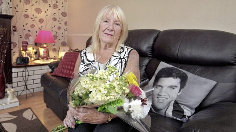Maureen Creaney, who was hit with a crowbar during a robbery at St Patrick&#39;s Church in Portadown on Friday, pictured last night with flowers she has received from well-wishers following the attack. Picture by Cliff Donaldson. 