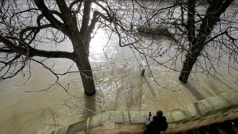 A man takes a photo of the Seiner river with his mobile phone in Paris, France, on Friday. Picture by Michel Euler, Associated Press 