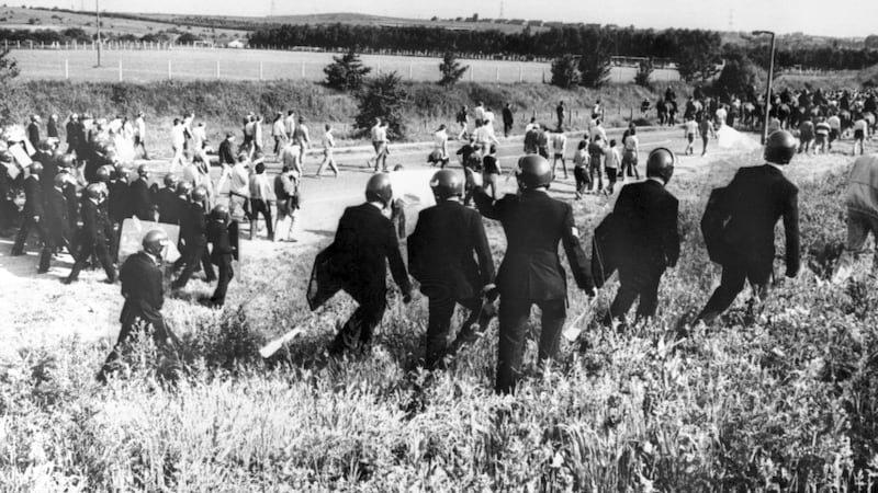 Police in anti-riot gear escort picketers away from their position near the Orgreave coking plant near Rotherham in 1984