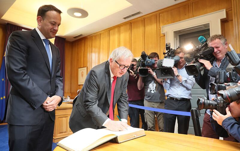 President of the European Commission, Jean-Claude Juncker, signs the visitors book in the private office of Taoiseach, Leo Varadkar (left) at Government Buildings, during his visit to Dublin&nbsp;