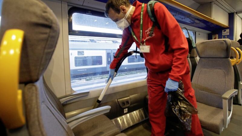 A cleaner sanitizes the carriage of a regional train, at the Garibaldi train station in Milan, Italy, yesterday. Authorities in the north have stepped up their response after a woman living in Belfast contracted the virus. Picture by Luca Bruno, Associated Press 