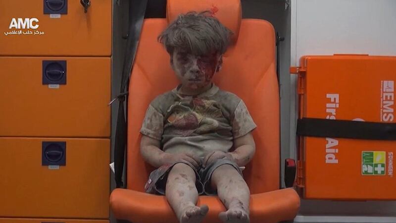 Omran Daqneesh (five) sits in an ambulance after being pulled out or a building hit by an airstirke, in Aleppo, Syria in August. The attack killed his 10-year-old brother Ali 