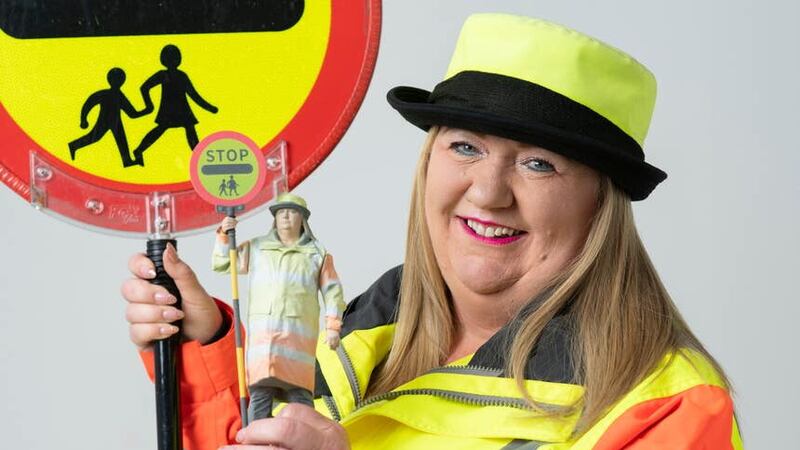 Lollipop lady Sandy Cox with her action figure (Ady Kerry/PinPep/PA)