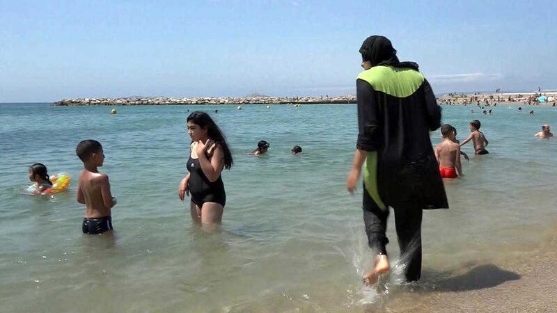 Nissrine Samali gets into the sea wearing a burkini, a wetsuit-like garment that also covers the head, in Marseille 