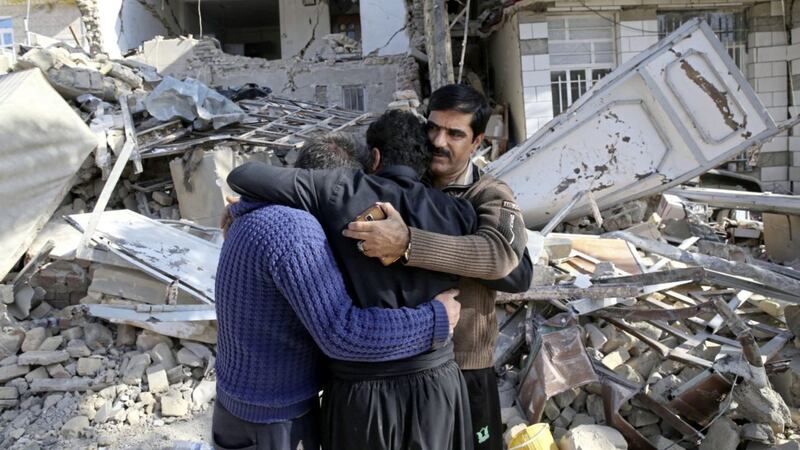 Earthquake survivors mourn in front of destroyed houses in Sarpol-e-Zahab in western Iran PICTURE: Vahid Salemi/AP 