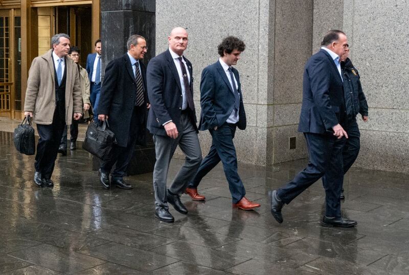 Cryptocurrency entrepreneur Sam Bankman-Fried, second from right, arrives for an appearance at Manhattan federal court in New York 
