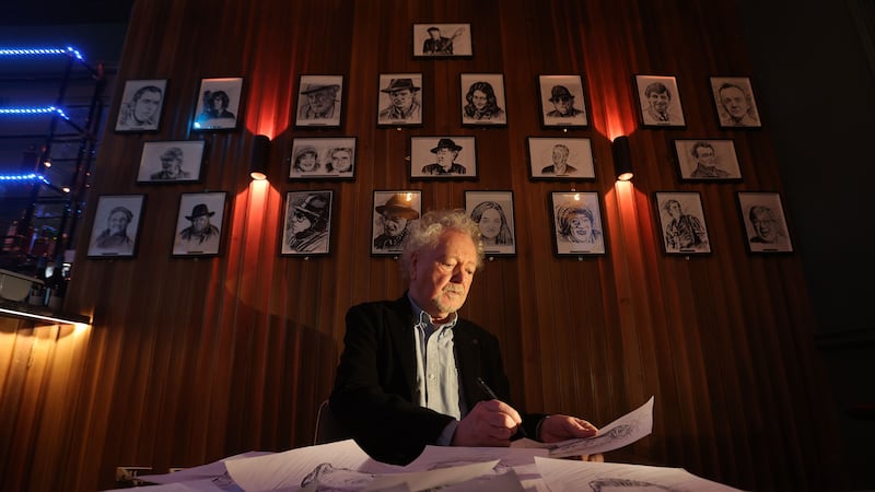 Artist Alan Quigley with his black and white sketches of local famous characters on display at the Monico bar, Lombard Street Belfast. Picture Mal McCann.
