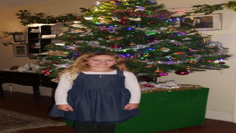 Bea Baldwin standing in front of a Christmas tree