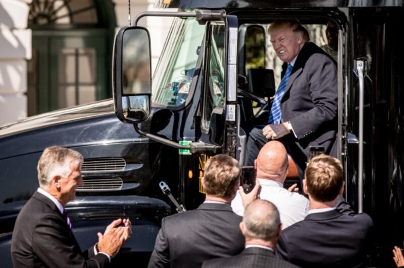 President Donald Trump jokes as he sits in the drivers seat 