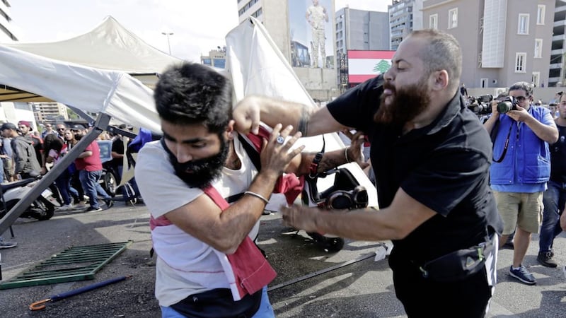 A Hezbollah supporter, right, fights with an anti-government protester in Beirut on Tuesday. Picture by Hassan Ammar/AP 