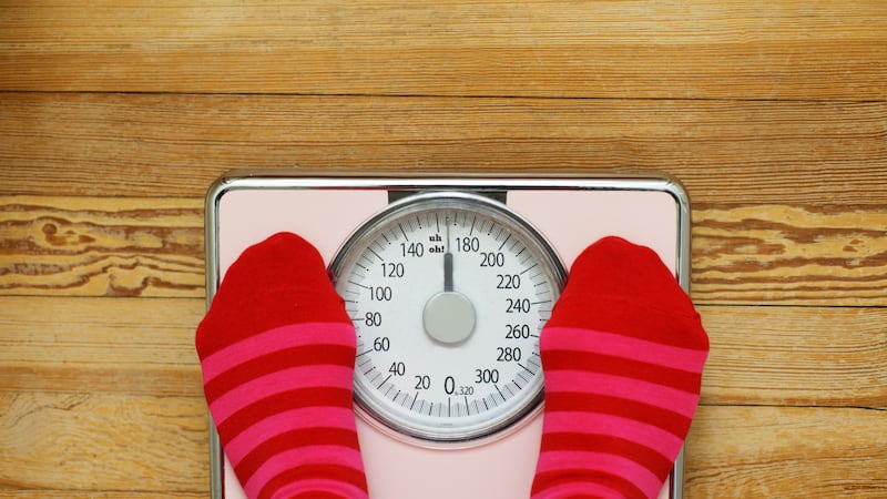 Feet in socks on weighing scale saying 'uh, oh'