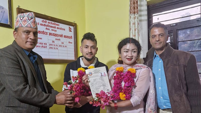 The couple show their marriage registration certificate at a village council office, located in the mountains west of the capital Kathmandu (Sunil Babu Pant via AP)