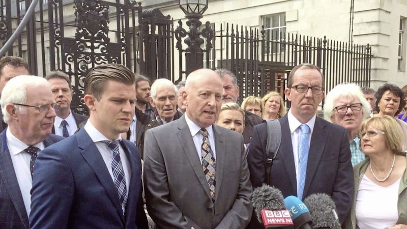 Edward Barnard, whose brother Patrick was murdered by the Glenanne gang, surrounded by lawyers and other relatives who have lost loved ones at hands of gang, speaking to the media outside Belfast High Court in July 2017 