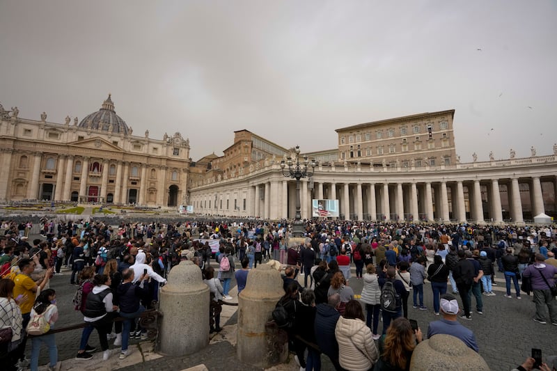 People gather in St Peter’s Square at the Vatican as Pope Francis recites the Angelus noon prayer from the window of his studio on Easter Monday (Andrew Medichini/AP)