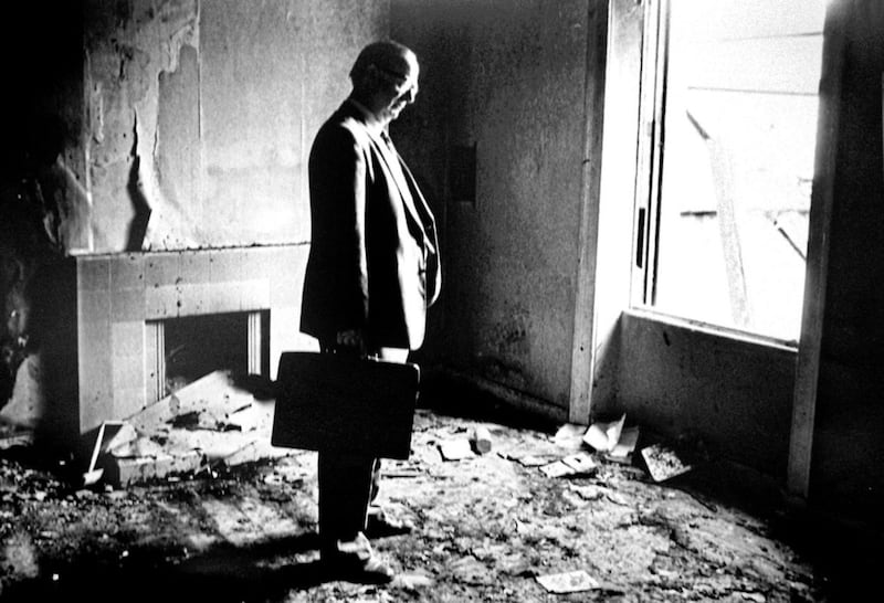Former SDLP leader Gerry Fitt standing in the burnt-out remains of his home on the Antrim Road in north Belfast in the early 1980s. Picture by Alan Lewis 