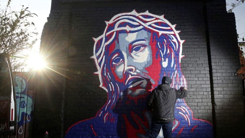 Street artist Glen Molloy paints a picture of Jesus on the Peaceline near Cupar Way, it is done in the style of the iconic &quot;Hope&quot; image of Barack Obama designed by artist Shepard Fairey Picture Mal McCann. 