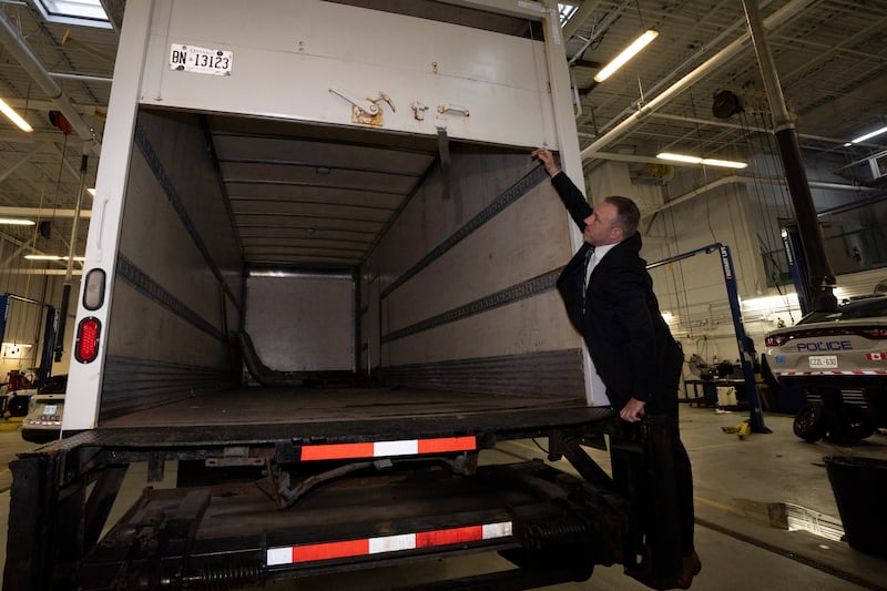 Police officers open the back of a recovered truck during a press conference in Brampton, Ontario (Arlyn McAdorey/The Canadian Press via AP)