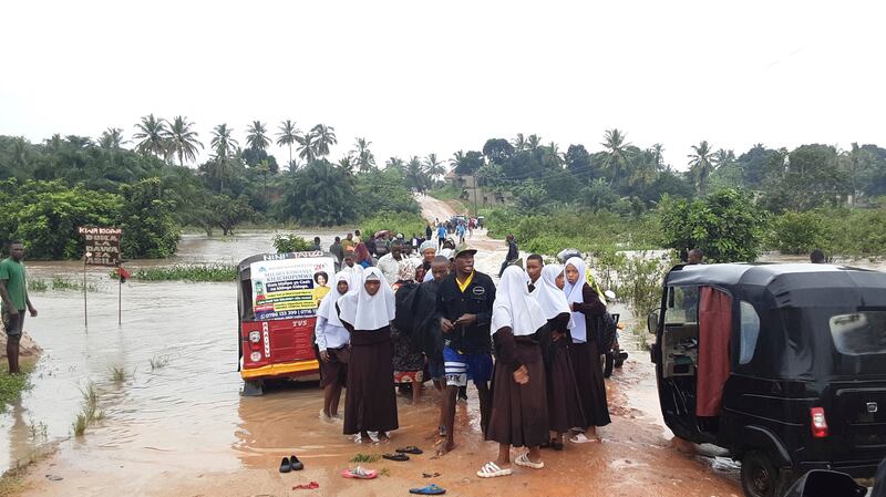 Schoolchildren stranded on a damaged River Zingiziwa bridge in Dar es Salaam (AP)