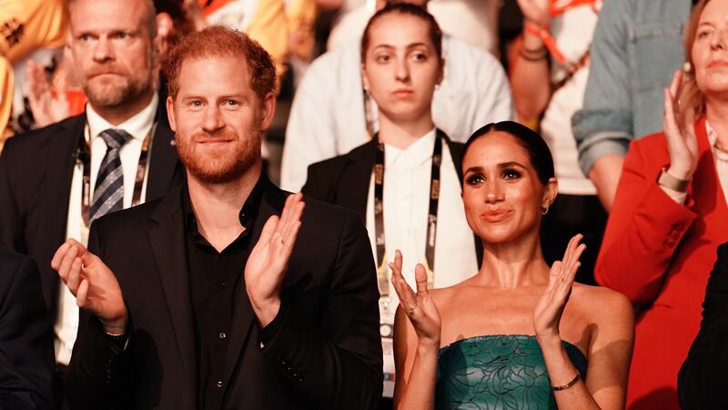 The Duke and Duchess of Sussex chose a shot of them smiling and clapping at this year’s Invictus Games in Germany