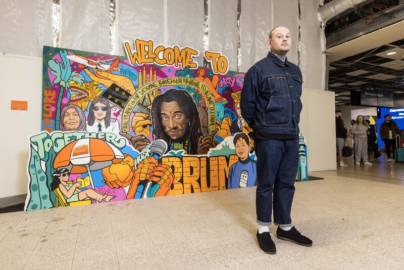 Street artist Gent 48 in front of his new mural at Birmingham Airport, marking the opening of easyJet’s newest UK base
