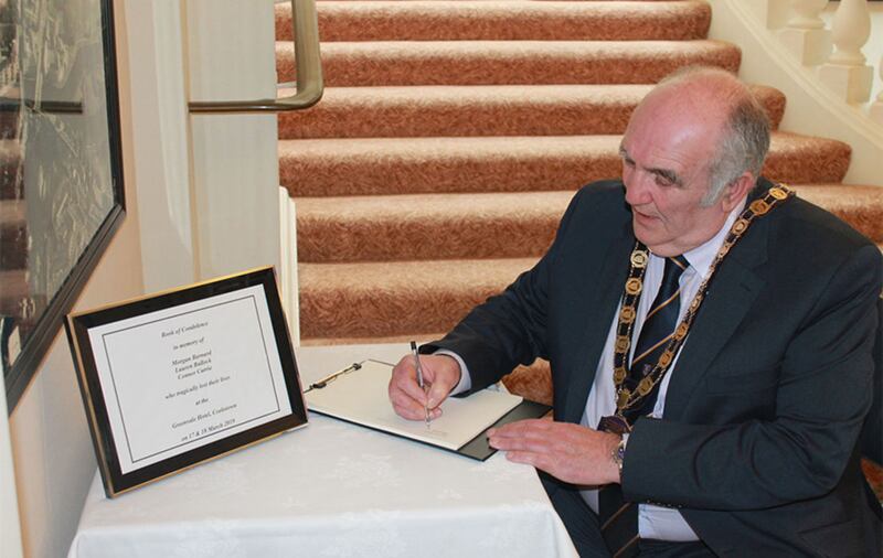 Chairman of Fermanagh and Omagh District Council, councillor Howard Thornton, signing a book of condolence in Enniskillen to the Cookstown victims&nbsp;
