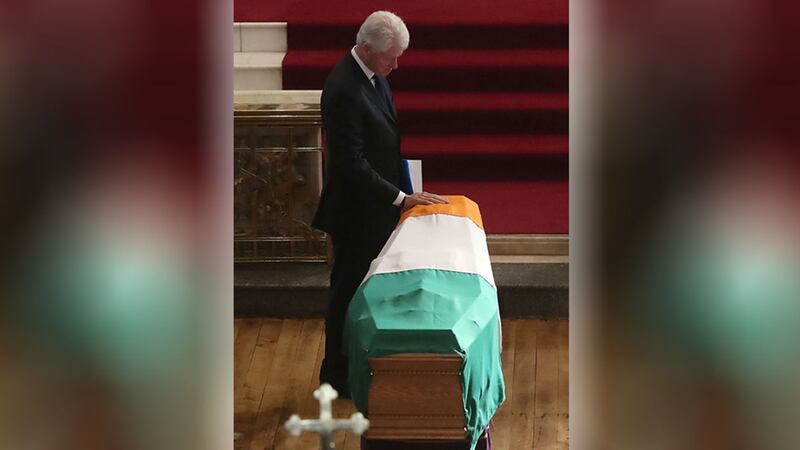Former US President Bill Clinton touches the coffin during the funeral of Martin McGuinness. Picture by Niall Carson, PA