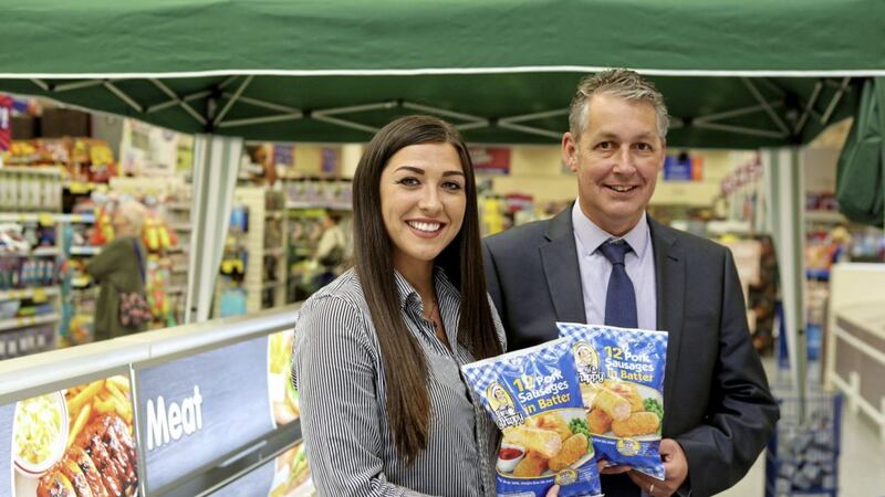 Sophie Peters, buyer for B&amp;M, with supplier Nigel Williams of TS Foods and the battered sausages that will now be in store. 