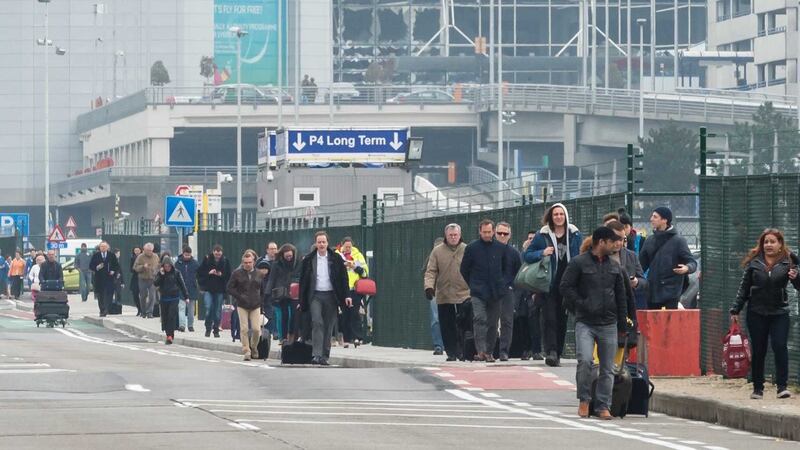People walk away from Brussels airport after explosions rocked it. Picture by&nbsp;Geert Vanden Wijngaert,&nbsp;AP Photo