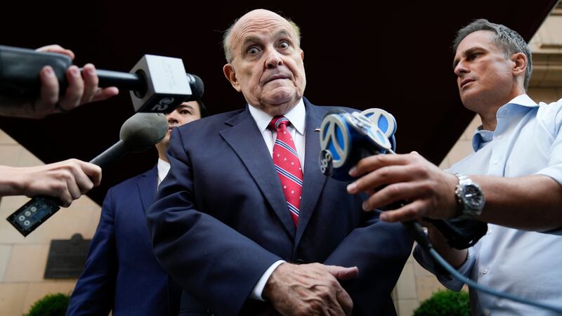 Rudy Giuliani speaks to reporters as he leaves his flat in New York (Seth Wenig/AP)