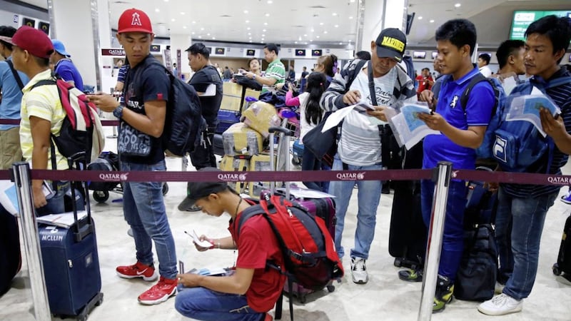 Despite a temporary suspension of the deployment of Filipino workers to Qatar by the Labor Department on Tuesday, Overseas Filipino Workers (OFWs) queue up at Qatar Airways check-in counter for the scheduled flight to Doha on Wednesday. Picture by Bullit Marquez, Associated Press 