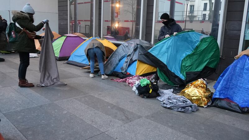 Activists helped migrants pack their belongings after they were woken before dawn by officers (Nicolas Garriga/AP)