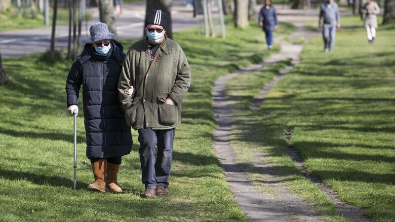 &nbsp;A couple wearing protective face masks walk through The Meadows, Edinburgh, during the sunny Easter bank holiday weekend, as the UK continues in lockdown to help curb the spread of the coronavirus.