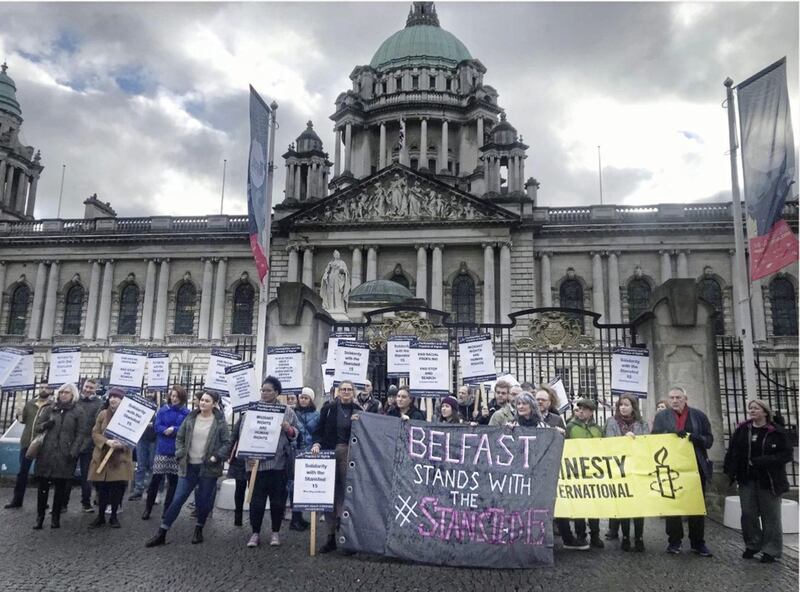 Journalists Trevor Birney and Barry McCaffrey with migrant rights activists at a rally outside Belfast City Hall. Picture by Hugh Russell 