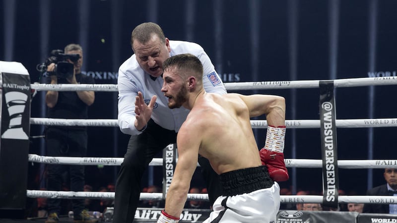 Ryan Burnett reaches for his lower back as referee Howard Foster begins the count. That injury would signal the end of the fight at the end of the fourth round. Picture by PA