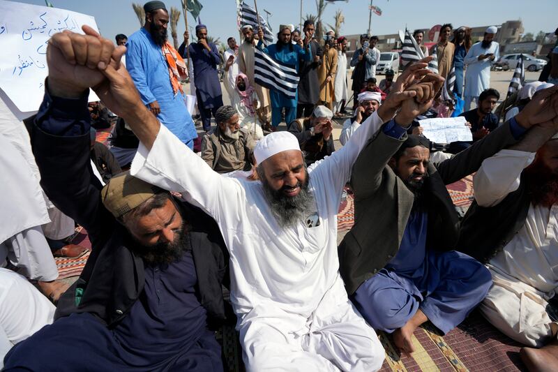 Supporters of religious party Jamiat Ulema-e-Islam block a road in Karachi as they protest against the delayed election result (Fareed Khan/AP)