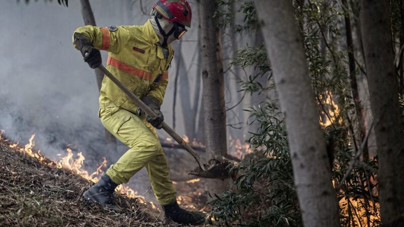 A firefighter works on an active fire on a hillside outside the village of Monchique, in southern Portugal&#39;s Algarve region, on Monday. Picture by Javier Fergo, Associated Press 