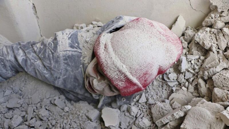 A child partly buried in rubble after airstrikes hit a rebel-held suburb near Damascus on Monday. Syrian opposition activists said more than one dozen people killed in new airstrikes PICTURE: Syrian Civil Defense White Helmets via AP 
