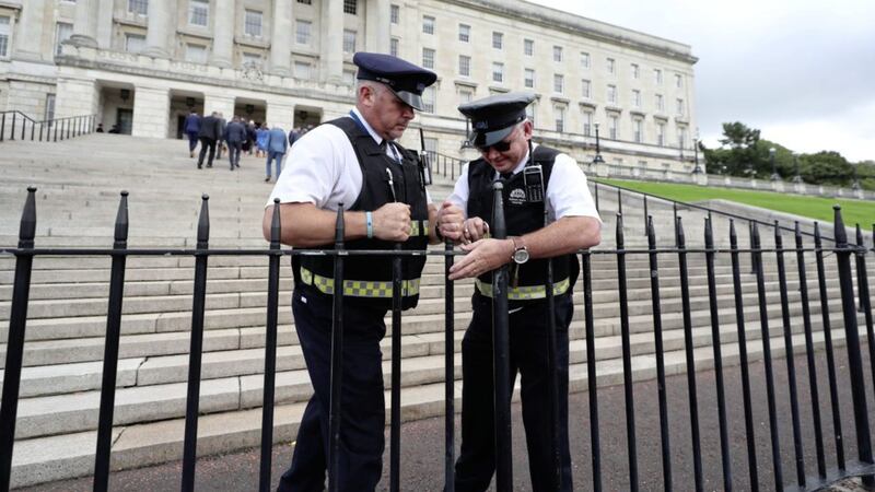 Security guards lock the gates outside Parliament Buildings at Stormont