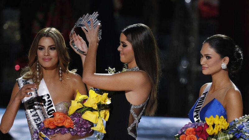 MISTAKE: Former Miss Universe Paulina Vega, center, removes the crown from Miss Colombia Ariadna Gutierrez, left, before giving it to Miss Philippines Pia Alonzo Wurtzbach, right, at the Miss Universe pageant on Sunday, in Las Vegas. Gutierrez was incorrectly named the winner before Wurtzbach was given the Miss Universe crown PICTURE: John Locher/AP 