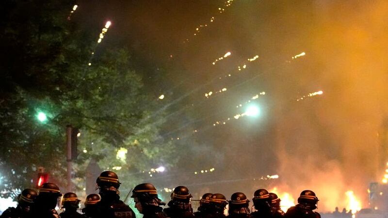 Fires could be seen burning at some intersections in the suburb and protesters shot fireworks at police, video from the suburb showed (Christophe Ena/AP)
