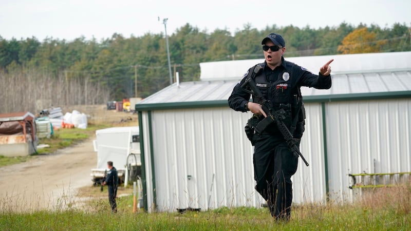 A police officer gives an order to the public during a search at a farm (Robert F. Bukaty/AP)