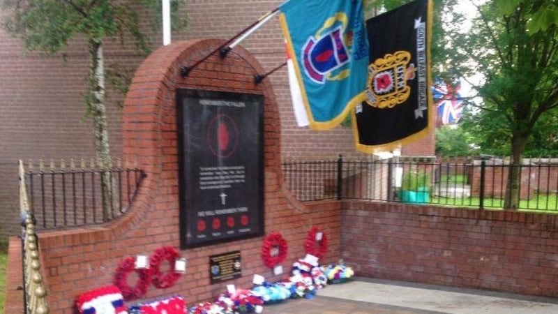 A temporary plaque honouring UDA members was placed on a memorial during the parade last night in south Belfast 
