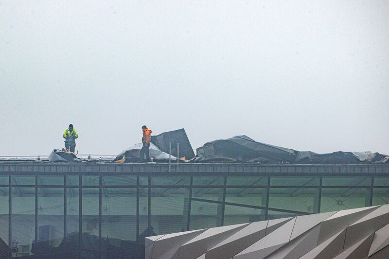 Workers inspect the damaged roof of the Northern Ireland visitor attraction Titanic Belfast