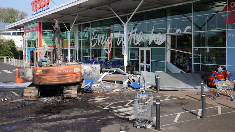 A burnt-out digger sits in front of the Tesco store in Crumlin following the theft of two ATMs&nbsp;