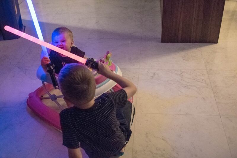 A baby plays with a lightsaber